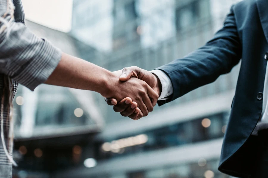 Two people shaking hands over a new deal