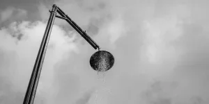 Брызги воды на душевой лейке из нержавеющей стали