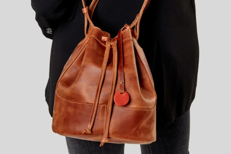 Femme portant un sac seau en cuir beige