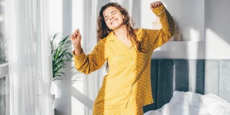 Mujer en pijama amarillo bailando por la mañana en casa
