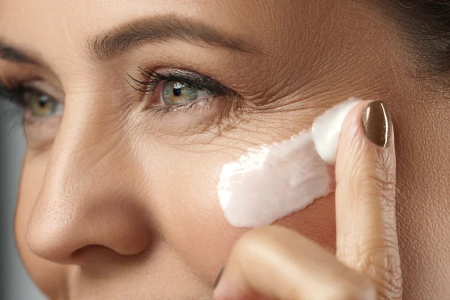 Woman running slow-aging cream on her face