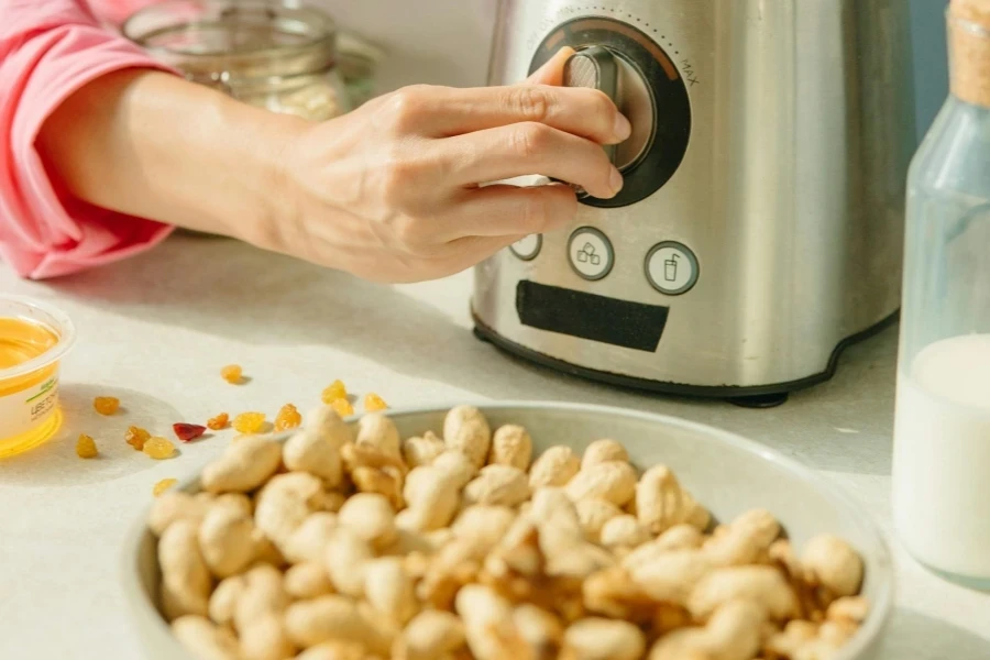 Woman turning on a blender while preparing nut milk