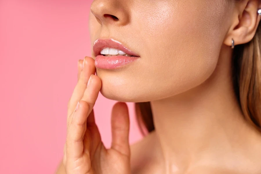 Woman with gorgeous lips on a pink background