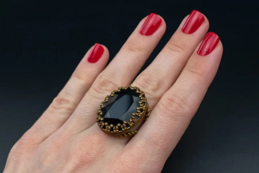 Mujer con esmalte de uñas rojo y un anillo vintage