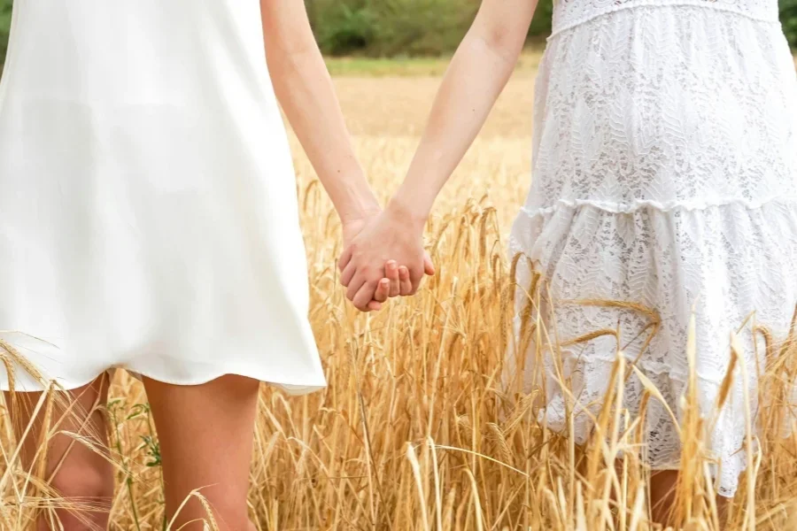 Women in White Dress Standing on the Grass Field
