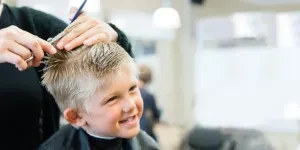 Young boy at barber shop getting short haircut