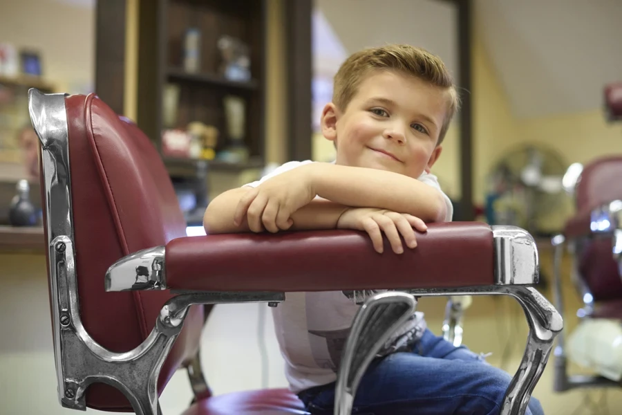 Young boy with new haircut sitting in barber’s chair