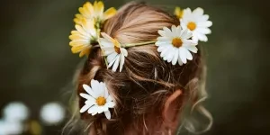 Young child with white and yellow flowers in long hair