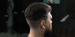 Young man getting new haircut at barber shop