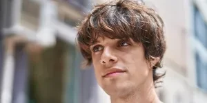 Young man with mod cut walking along street