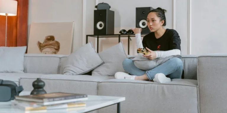 Young woman enjoying video games on a sofa in a stylish living room setting
