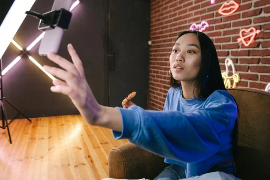 A woman uses her phone connected to a ring light