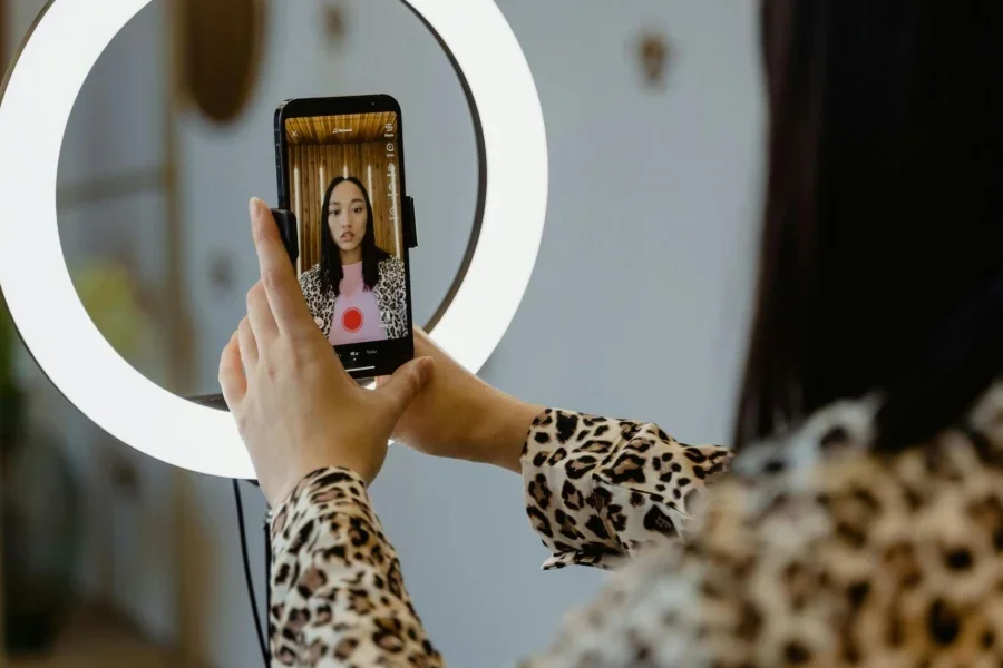 Una mujer usando un teléfono inteligente y un anillo de luz