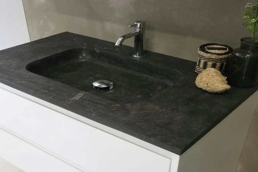A black washbasin with a stainless steel faucets