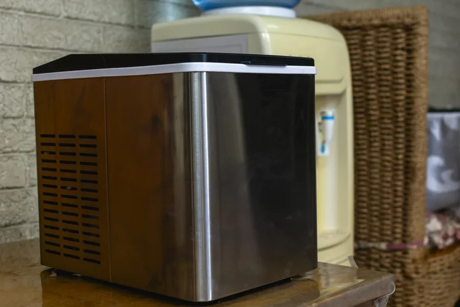Настольный льдогенератор рядом с диспенсером для воды