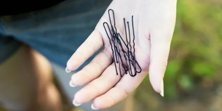 A girl holding several hairpins in summer outdoor closeup