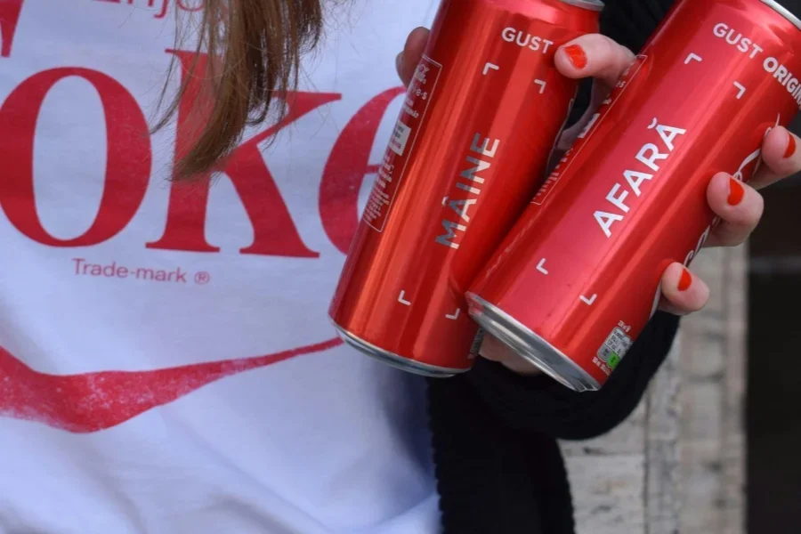 Eine Dame hält zwei Coca-Cola-Flaschen mit aufgedruckten Namen