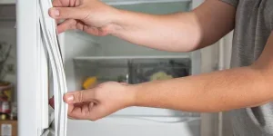 A man pulling a fridge gasket