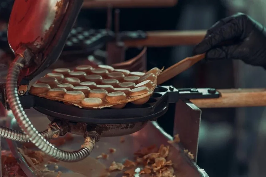 A person making waffles in a kitchen