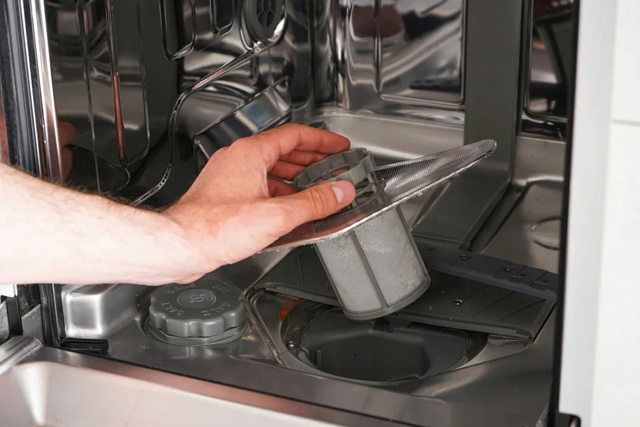 A person removing a dishwasher filter