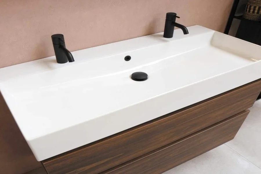 A white rectangular washbasin with two faucets