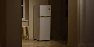 A white refrigerator in dimly lit space