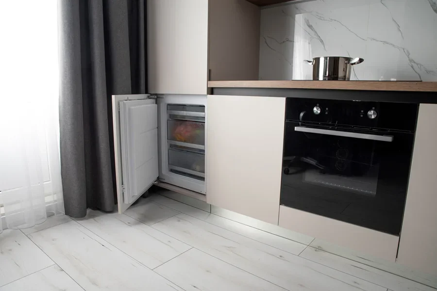 Un réfrigérateur blanc sous plan de travail, prêt à être installé.