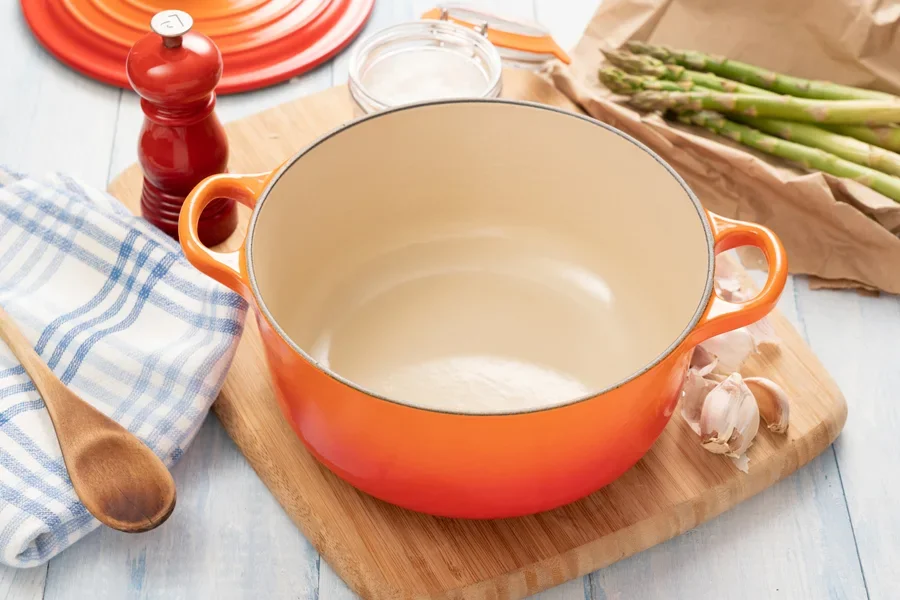 An orange-colored ceramic Dutch oven