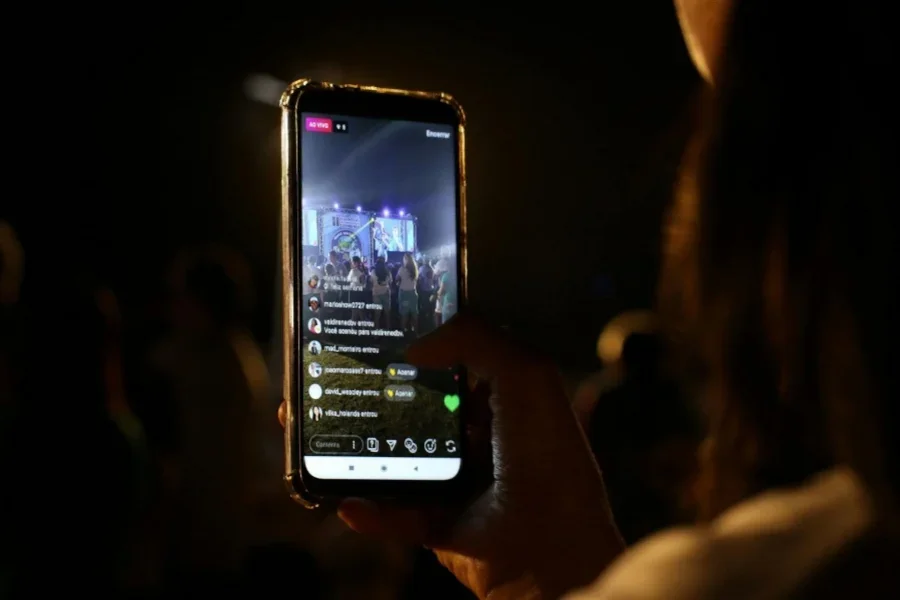 Fotografía de cerca de una persona grabando una actuación en directo con su teléfono móvil
