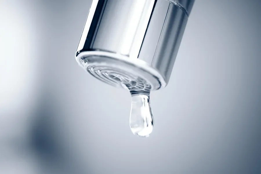 Close up of a drop of water falling from the faucet