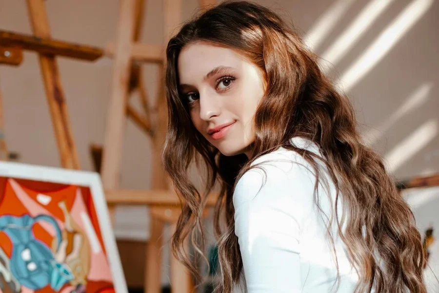 Фотография крупным планом женщины с каштановыми волнистыми волосами