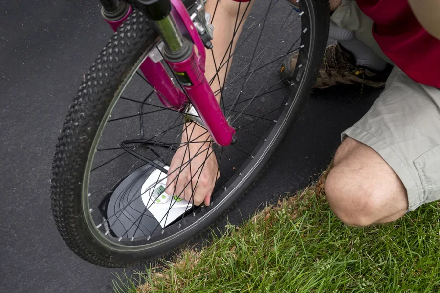 Komuter memasang nosel pompa mini ke ban depan