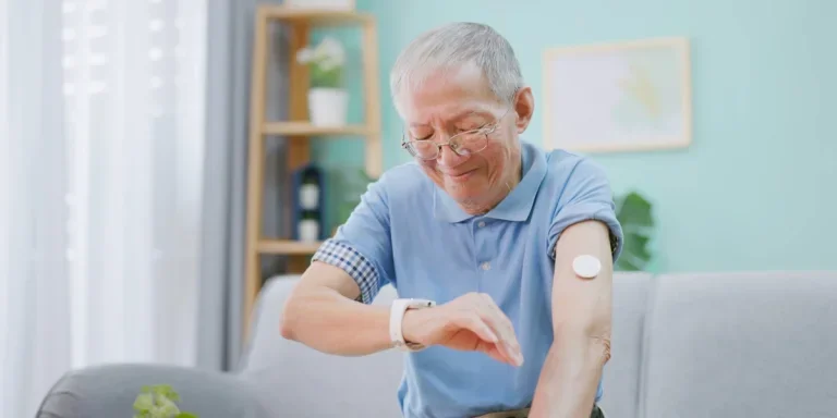 Elderly man wearing smartwatch and looking at phone