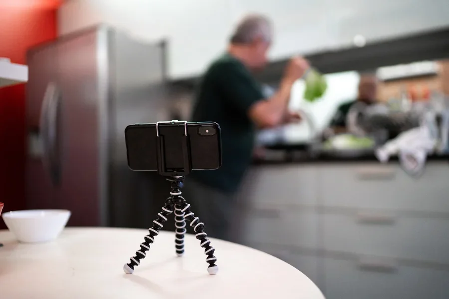 Flexible phone stand with a person in the kitchen behind