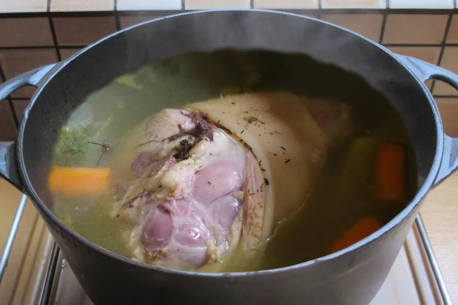 Food with herbs and spices cooking in a Dutch oven