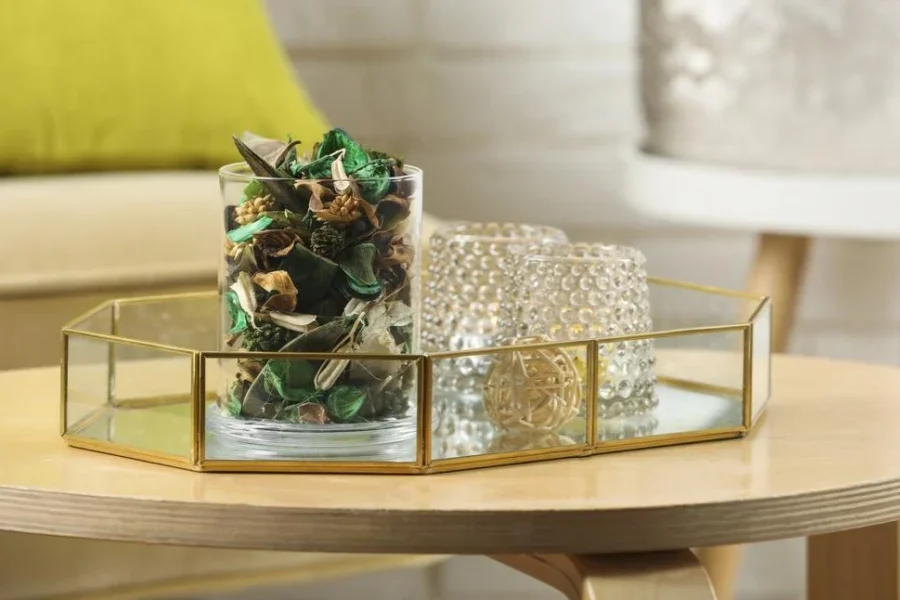 Glass jar with aromatic potpourri of dried flowers and different decor element on wooden table indoors