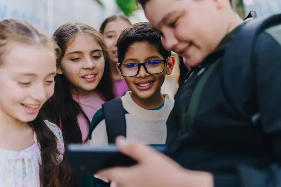 Niños viendo un vídeo en un teléfono móvil.