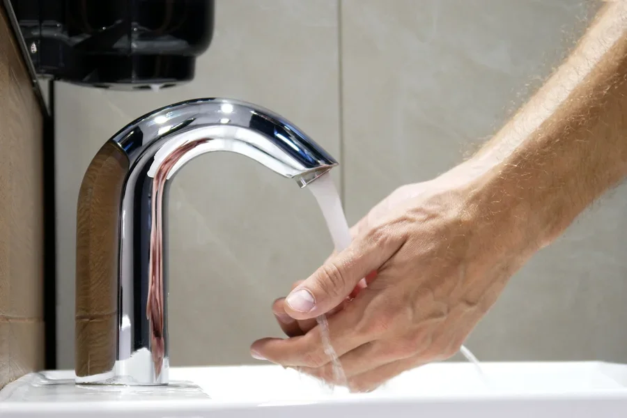 Man washing hands with touchless faucet