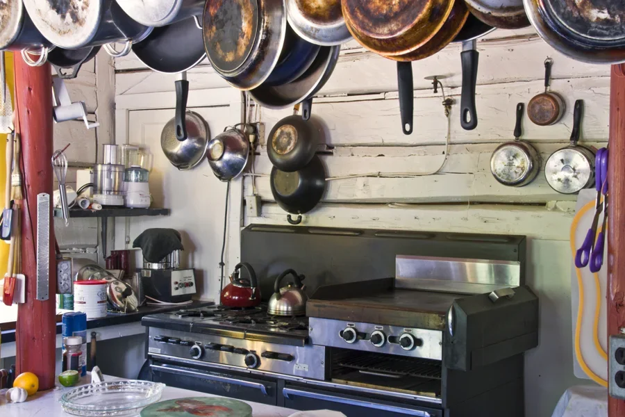Messy kitchen with flat iron grill on stovetop