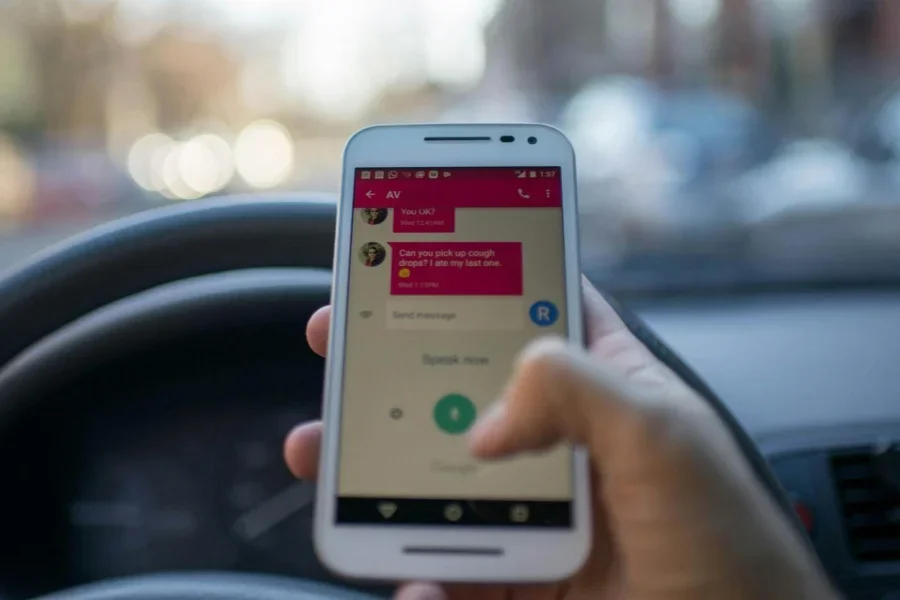 Person Holding White Smartphone Inside Vehicle
