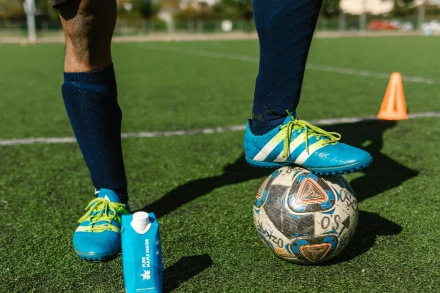 Persona con zapatos de fútbol sobre césped verde