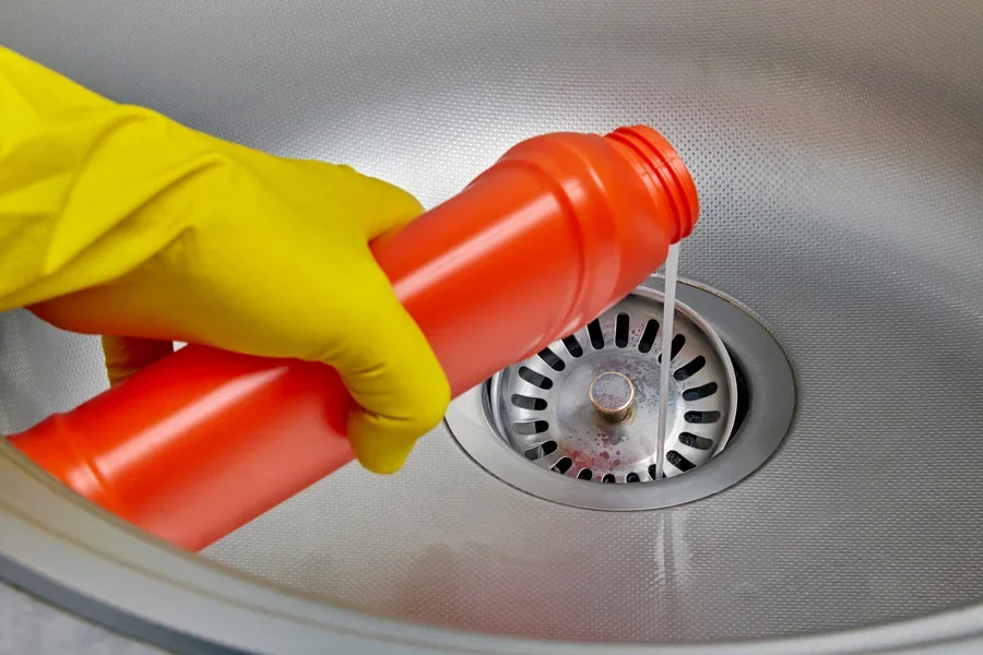 Person pouring sink cleaner into drain