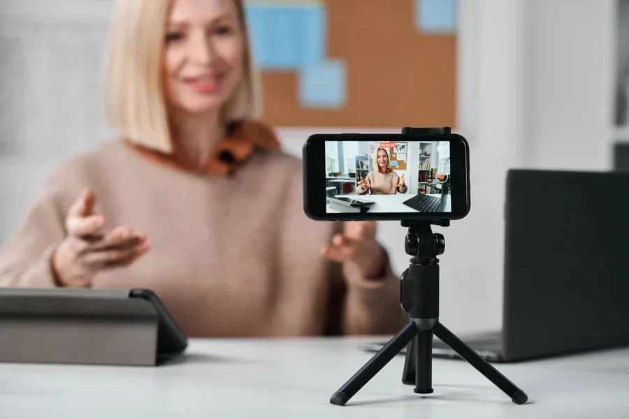 Person recording themselves with a smartphone on a tripod