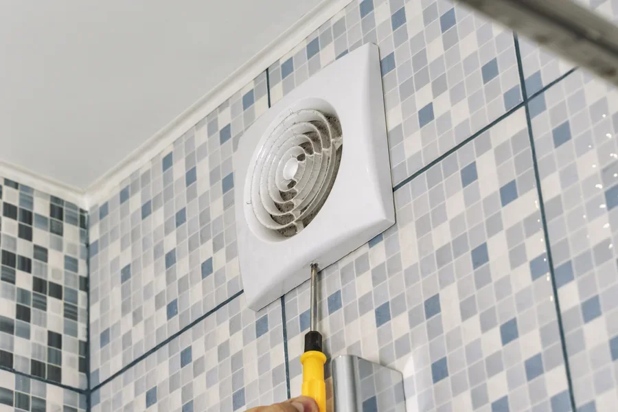 Person removing ventilation grill in a bathroom