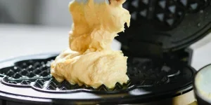 Raw dough placed on a waffle maker