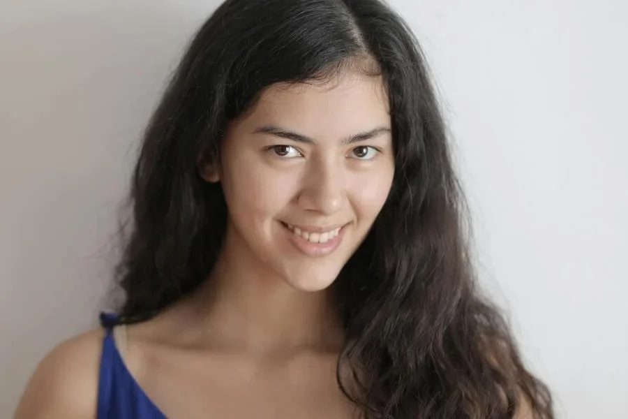 Улыбающаяся женщина с черными волнистыми волосами