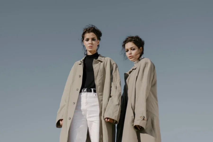 Two Women Wearing Beige Trench Coat Standing Next to Each Other