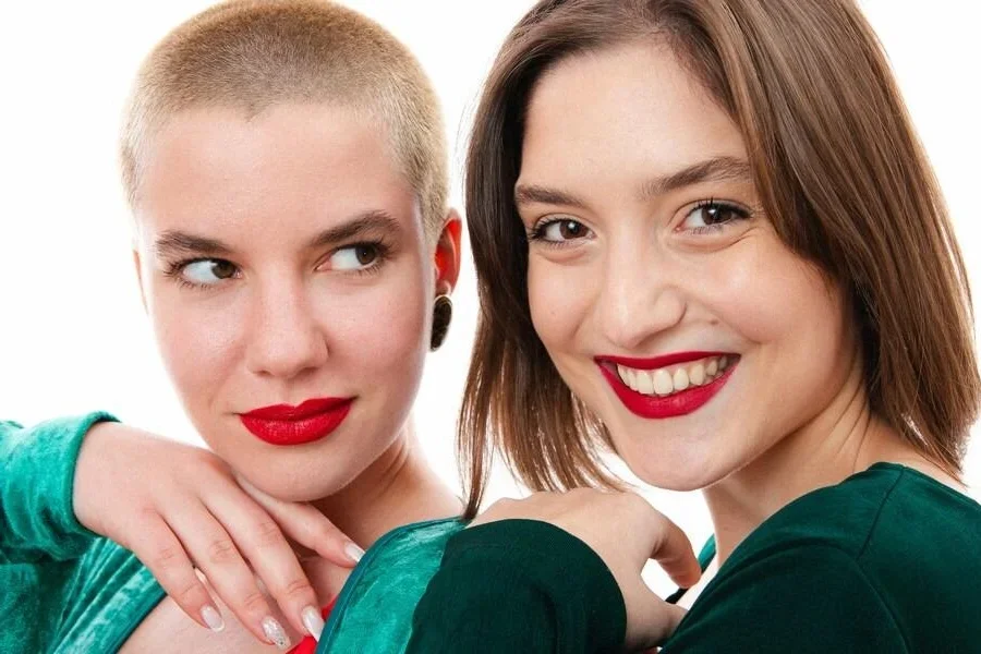 빨간 립스틱을 바른 두 여성이 사진을 찍고 있다