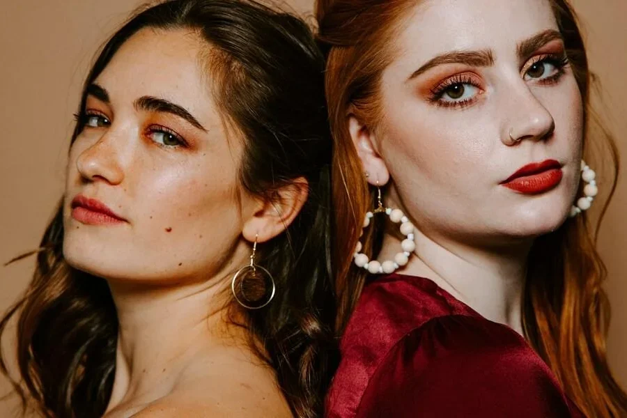 화장을 한 두 여성이 나란히 서 있다