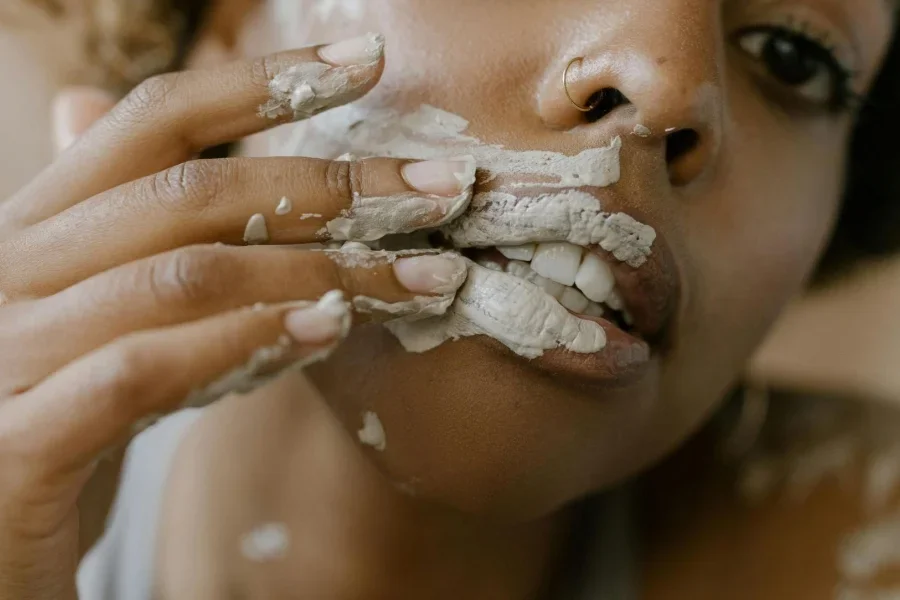 Mujer aplicándose una mascarilla de arcilla en la cara